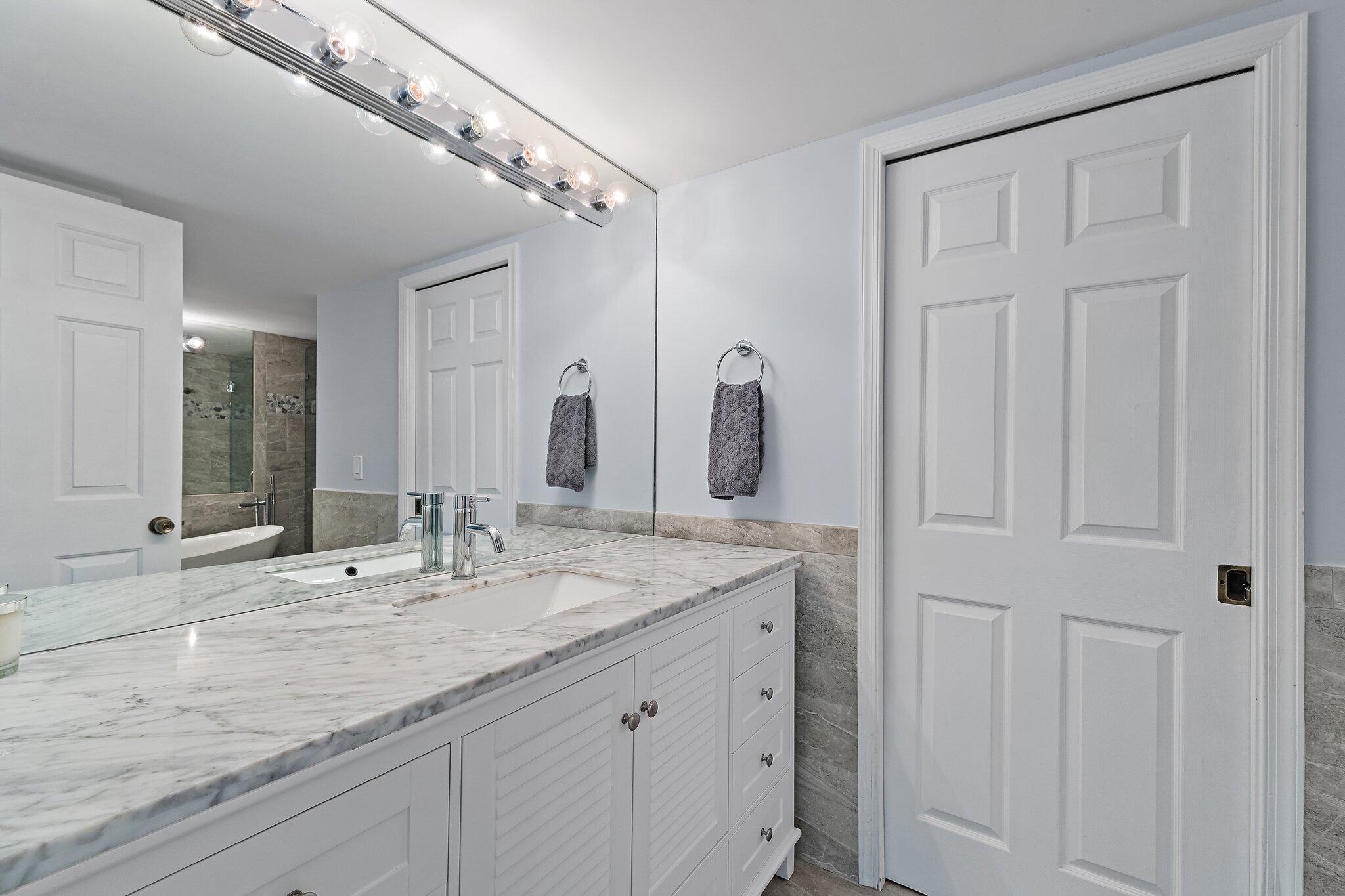 4161 U.S. Highway 1, Unit G3 Jupiter, FL 33477 - Photo 32 of 71 a bathroom with a double vanity sink and a mirror