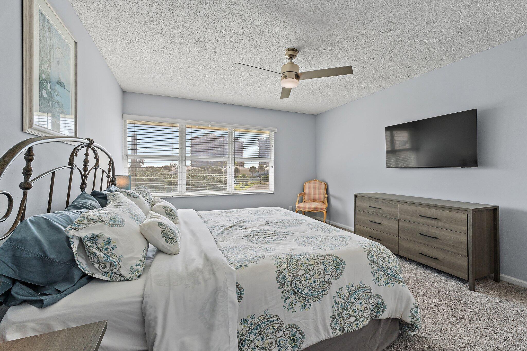 4161 U.S. Highway 1, Unit G3 Jupiter, FL 33477 - Photo 44 of 71 a bedroom with a large bed and a flat screen tv