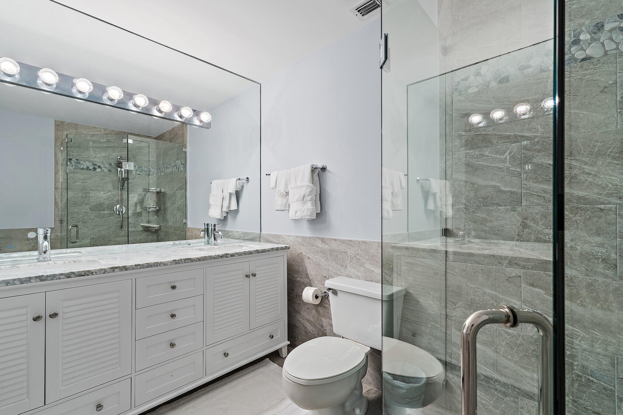 4161 U.S. Highway 1, Unit G3 Jupiter, FL 33477 - Photo 46 of 71 a bathroom with a granite countertop sink mirror vanity and toilet