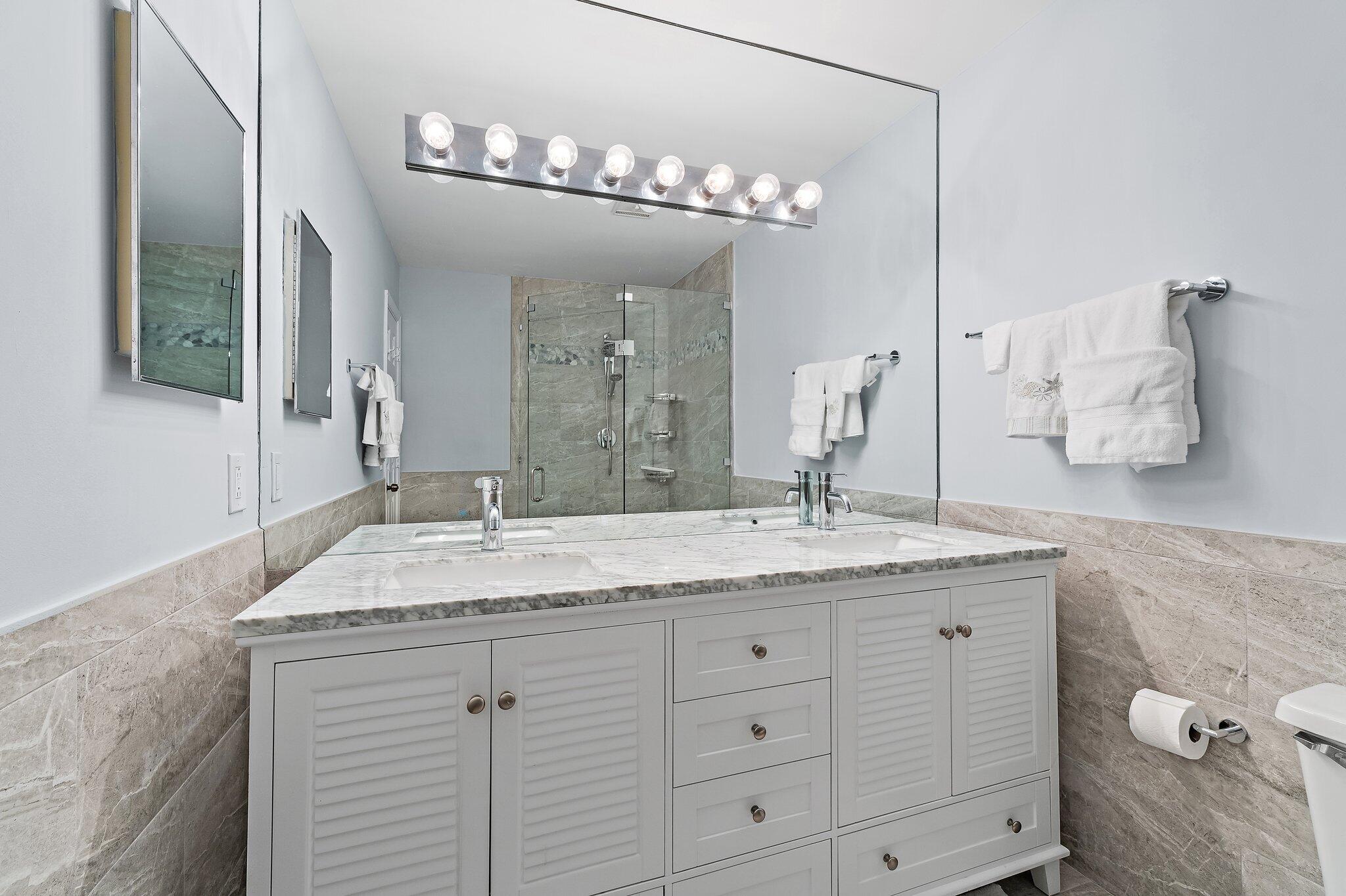 4161 U.S. Highway 1, Unit G3 Jupiter, FL 33477 - Photo 47 of 71 a bathroom with a granite countertop sink a large mirror and vanity