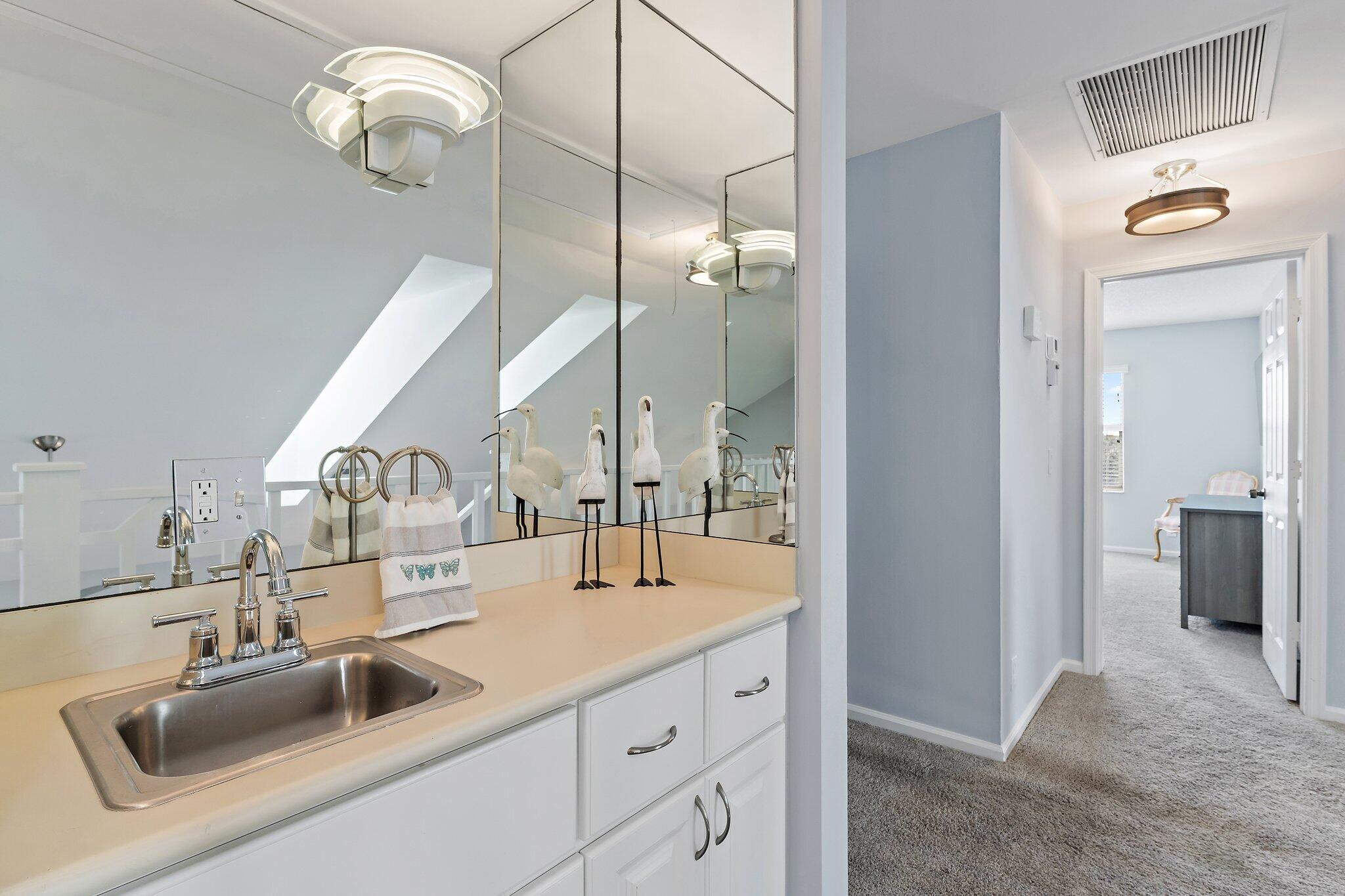4161 U.S. Highway 1, Unit G3 Jupiter, FL 33477 - Photo 49 of 71 a bathroom with a double vanity sink a mirror and a light fixture