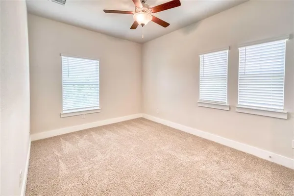 an empty room with a window and a ceiling fan