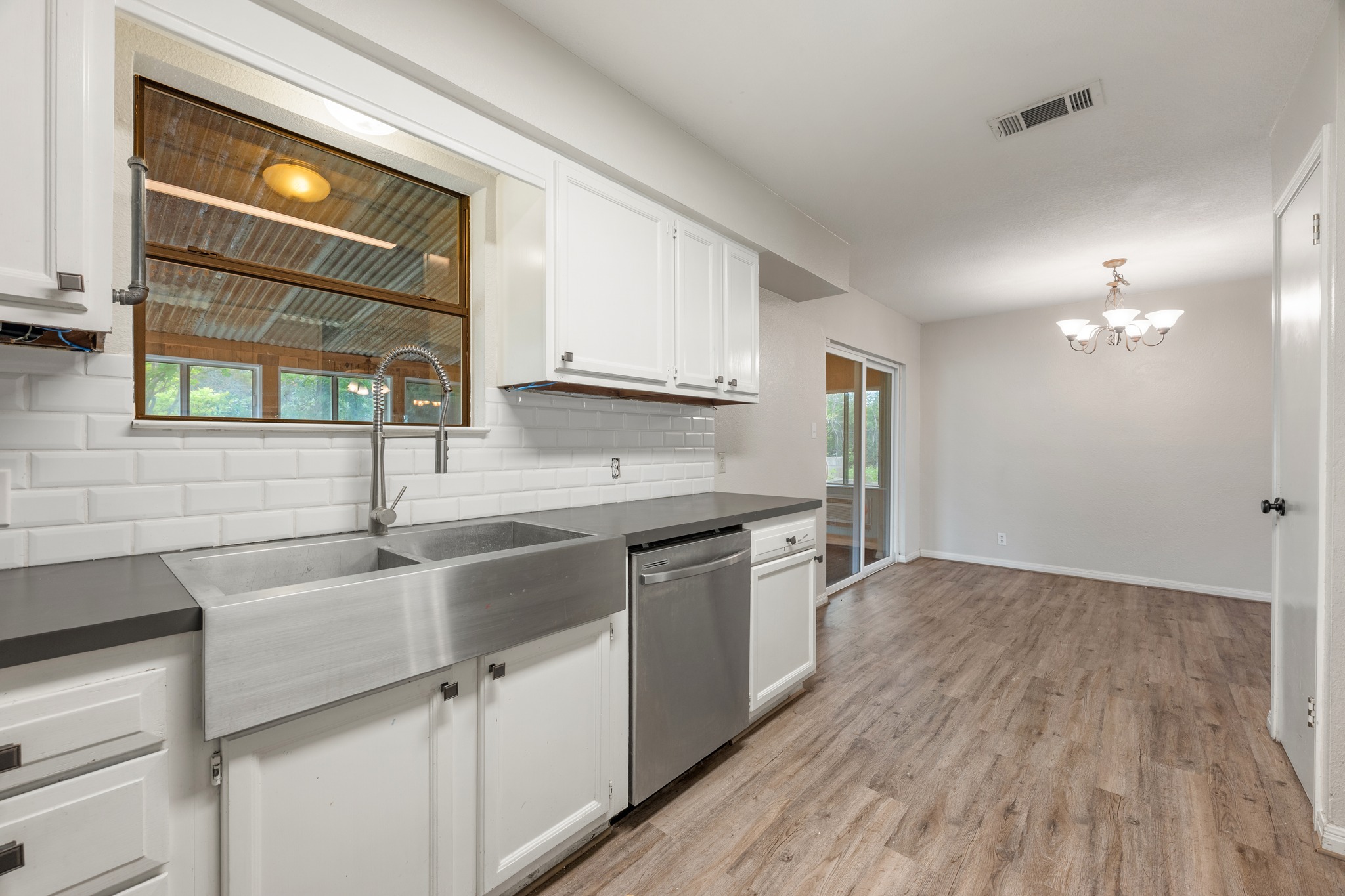 110 Skyview Terrace Leander, TX 78641 - Photo 13 of 26 Kitchen featuring a stainless steel farmhouse sink with a gooseneck faucet, white subway tile backsplash, and dark countertops