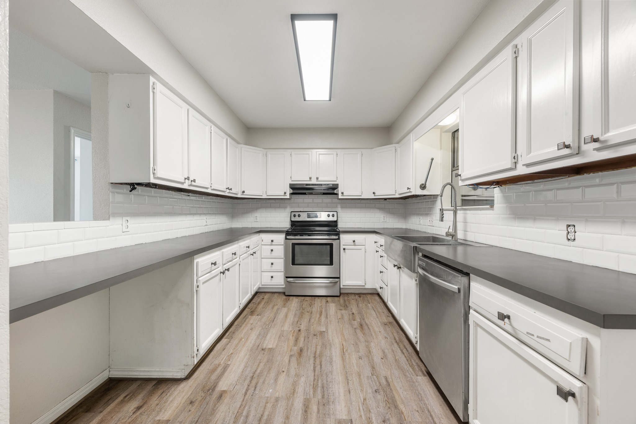 110 Skyview Terrace Leander, TX 78641 - Photo 14 of 26 U-shaped kitchen featuring white cabinetry, dark countertops, a subway tile backsplash, and stainless steel appliances