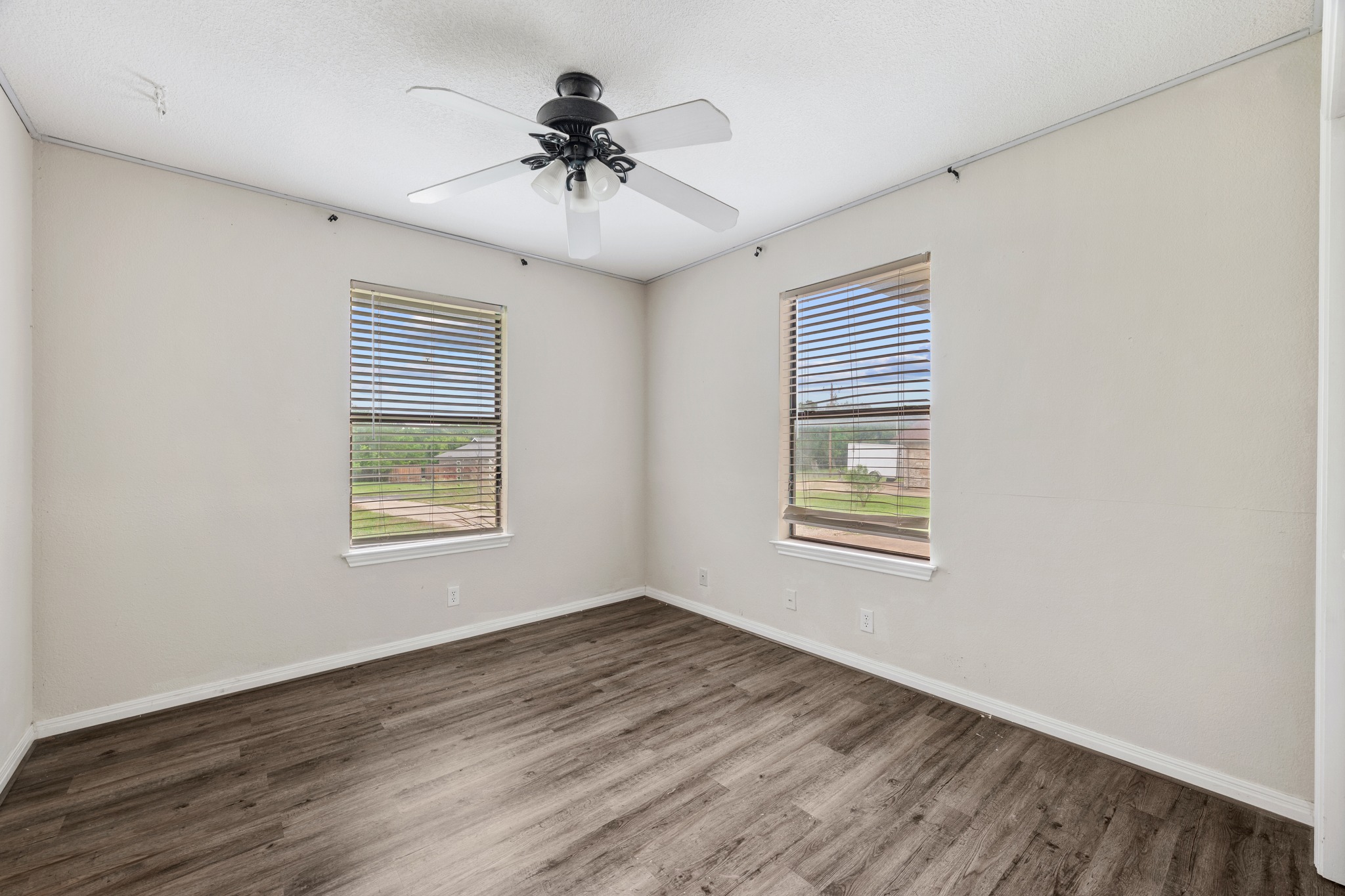 110 Skyview Terrace Leander, TX 78641 - Photo 18 of 26 Room featuring two windows with blinds, wood-finish flooring, a ceiling fan with integrated lighting, and neutral wall tones