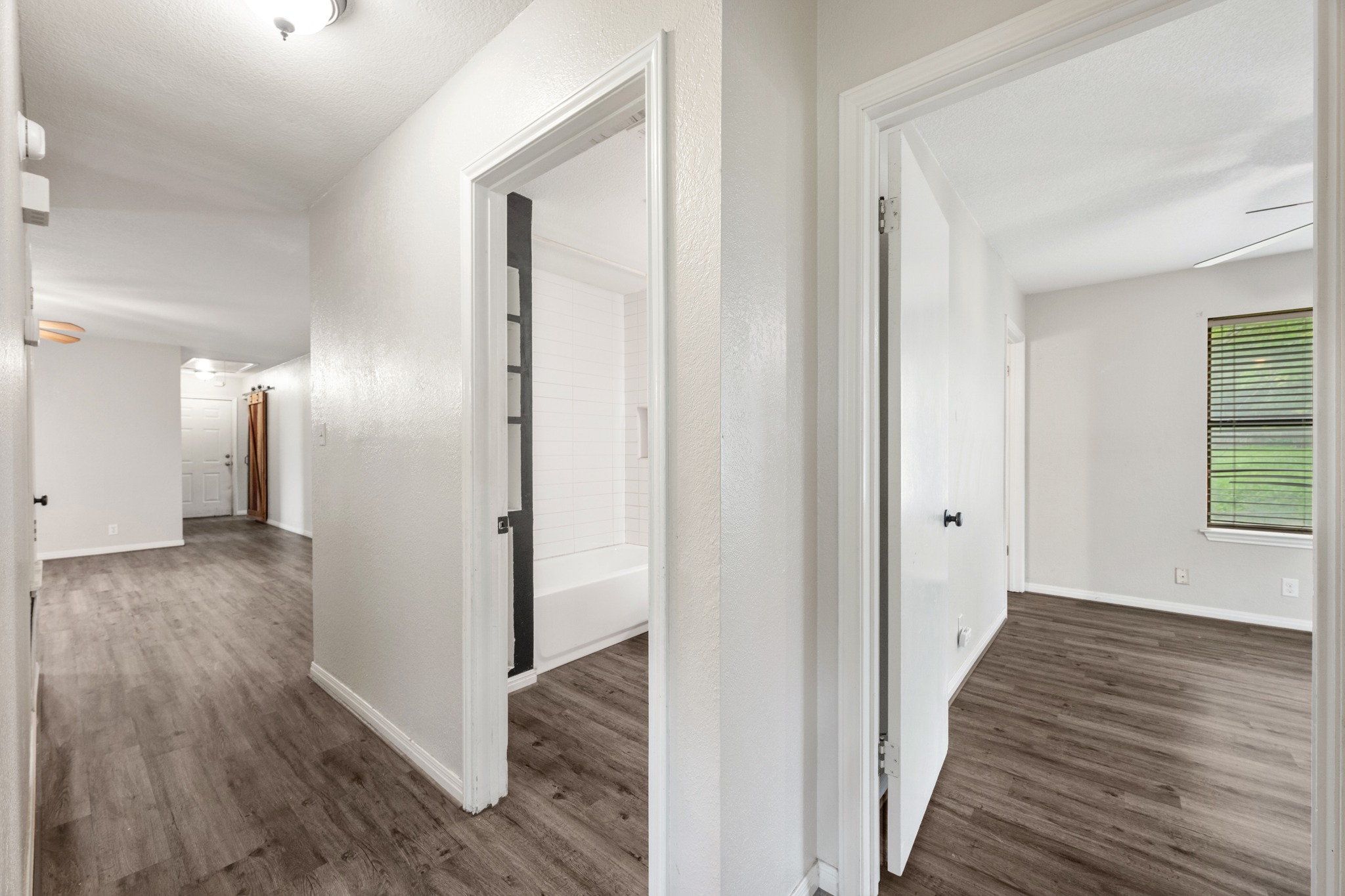 110 Skyview Terrace Leander, TX 78641 - Photo 20 of 26 Hallway featuring wood-finish flooring, white painted walls, and ceiling-mounted lighting fixtures