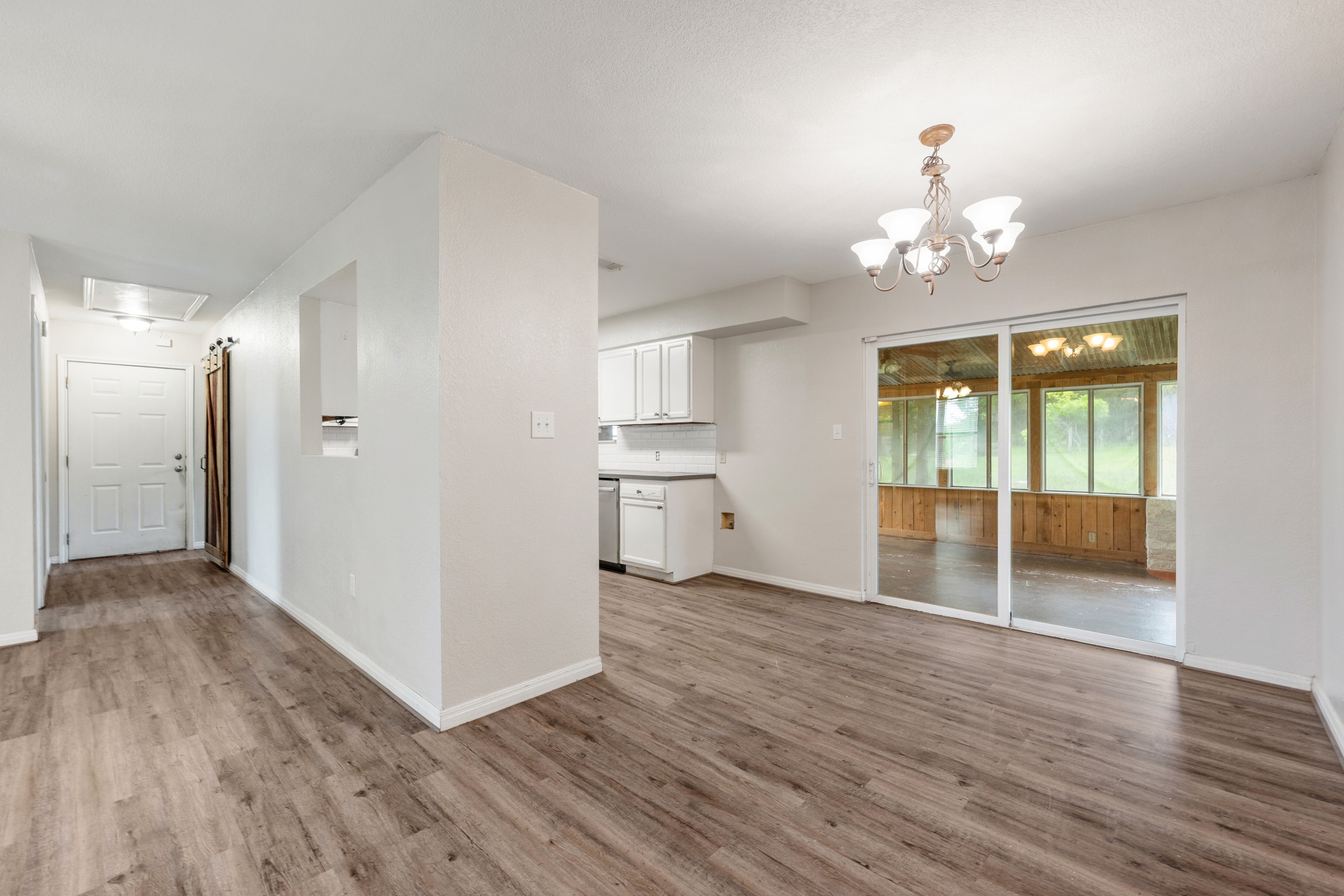 110 Skyview Terrace Leander, TX 78641 - Photo 8 of 26 Expansive wood-finish flooring throughout, featuring a bright white kitchen with white cabinetry and stainless steel appliances