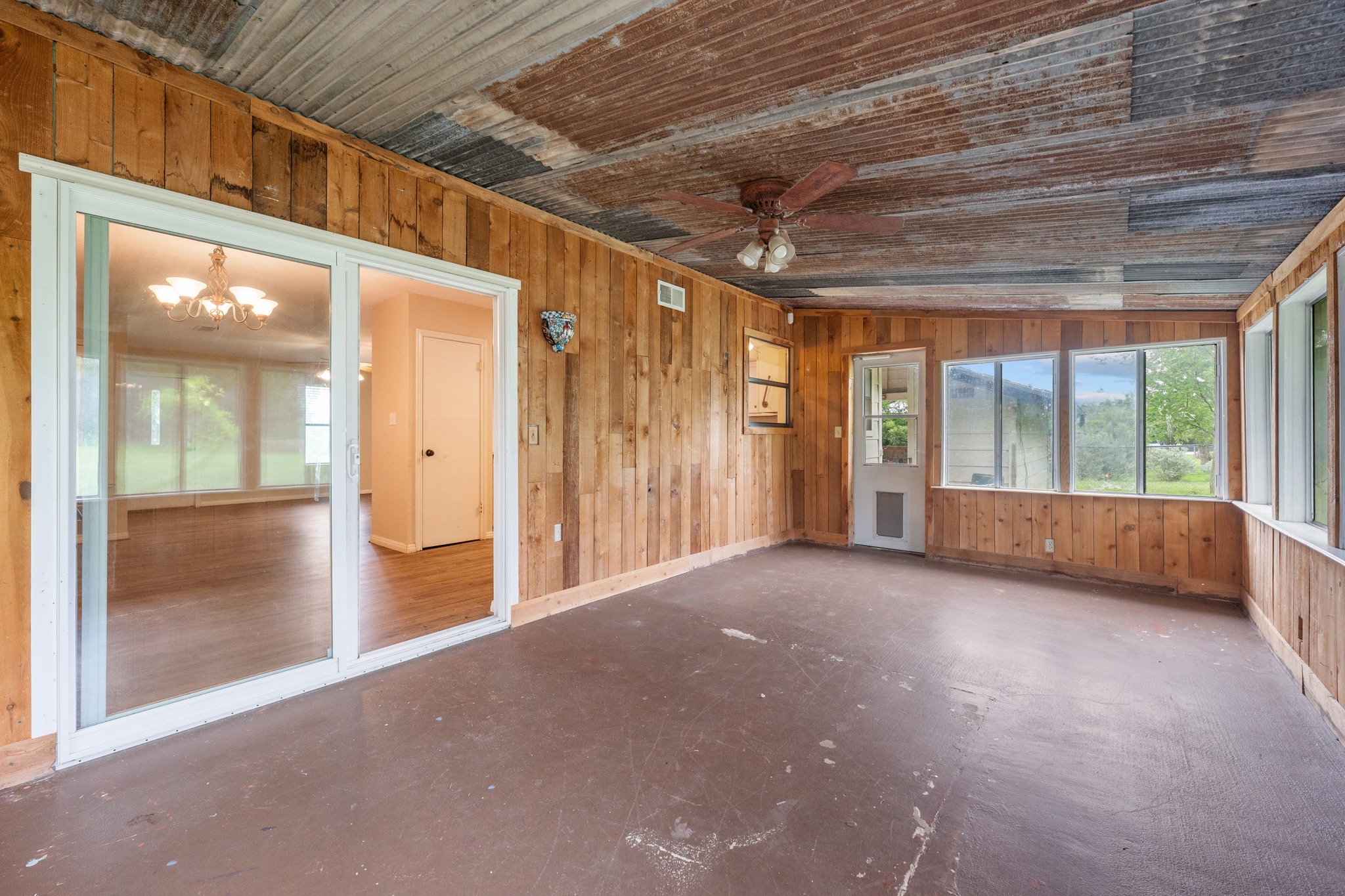 110 Skyview Terrace Leander, TX 78641 - Photo 10 of 26 Enclosed patio featuring wood paneling, multiple windows, a ceiling fan, and a corrugated metal ceiling