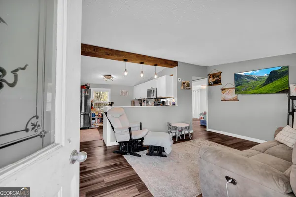 a living room with furniture and kitchen view