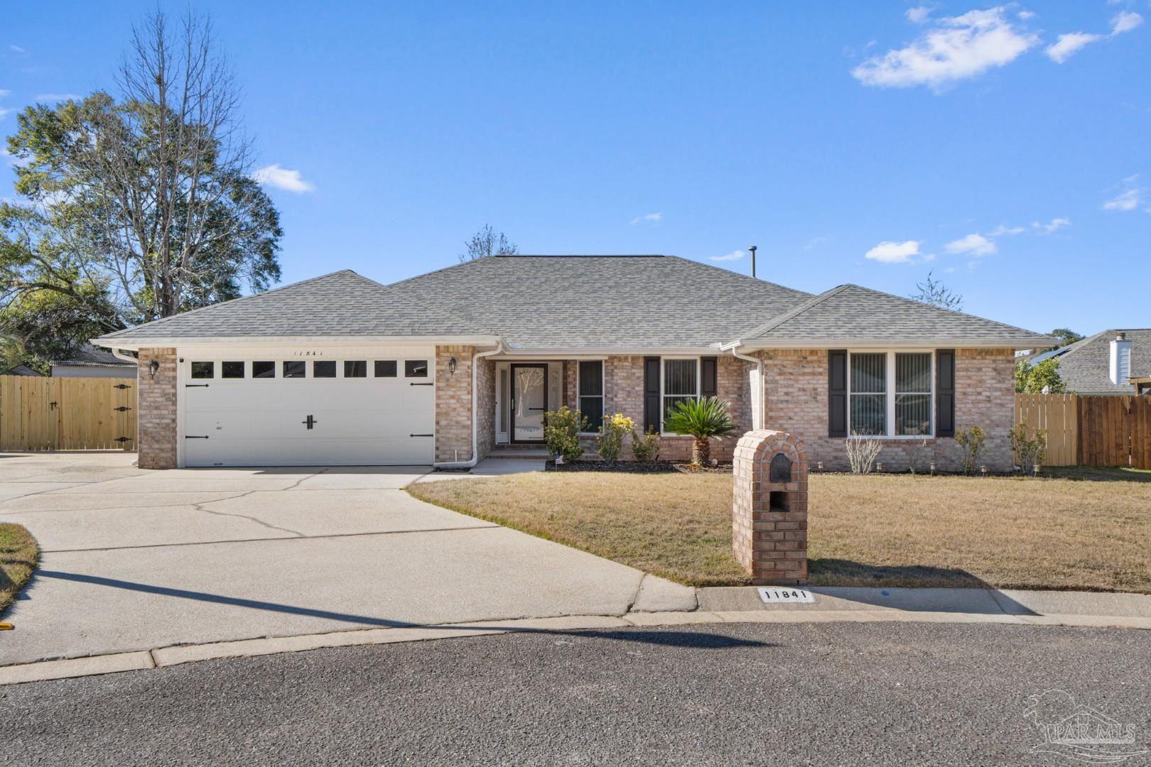 a front view of a house with yard and parking