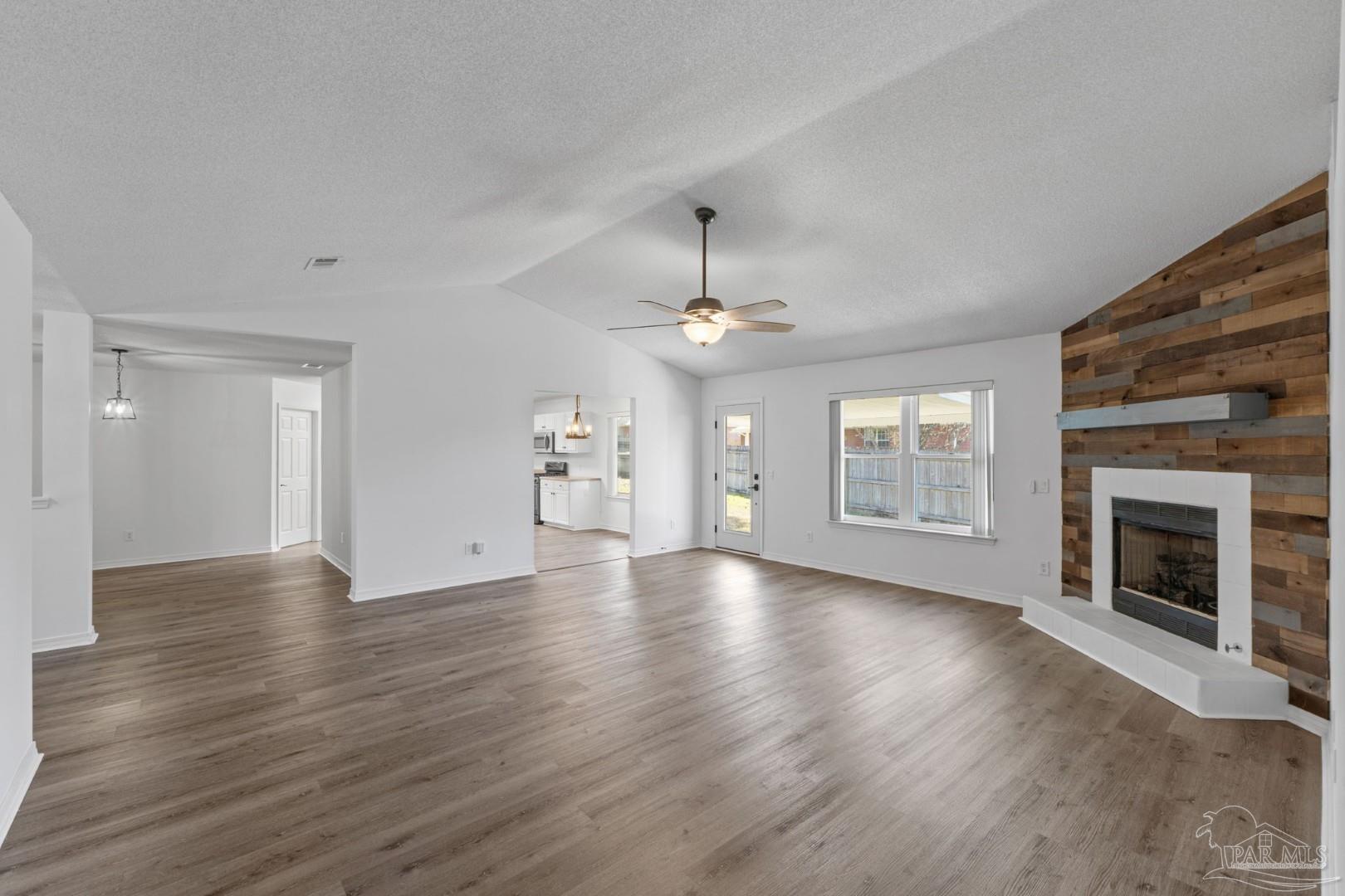 11841 Old Course Road Cantonment, FL 32533 - Photo 13 of 46 an empty room with wooden floor fireplace and windows