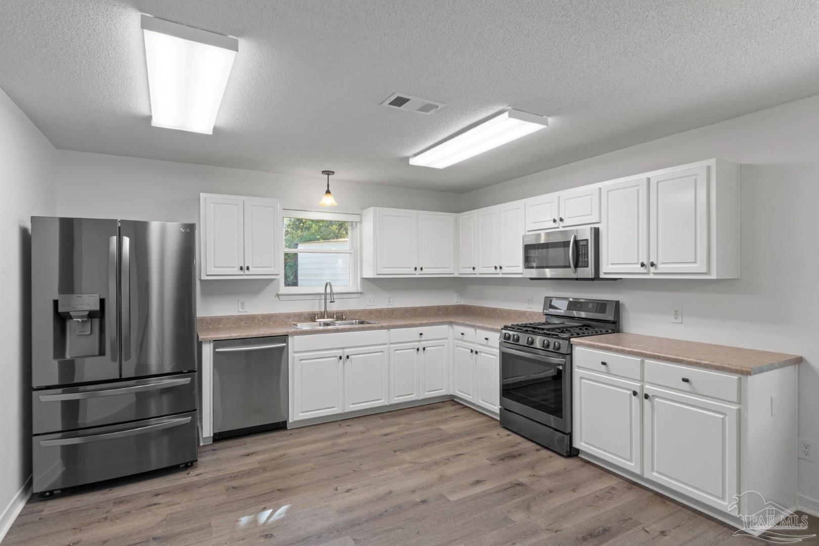 11841 Old Course Road Cantonment, FL 32533 - Photo 17 of 46 a kitchen with a sink stove and refrigerator