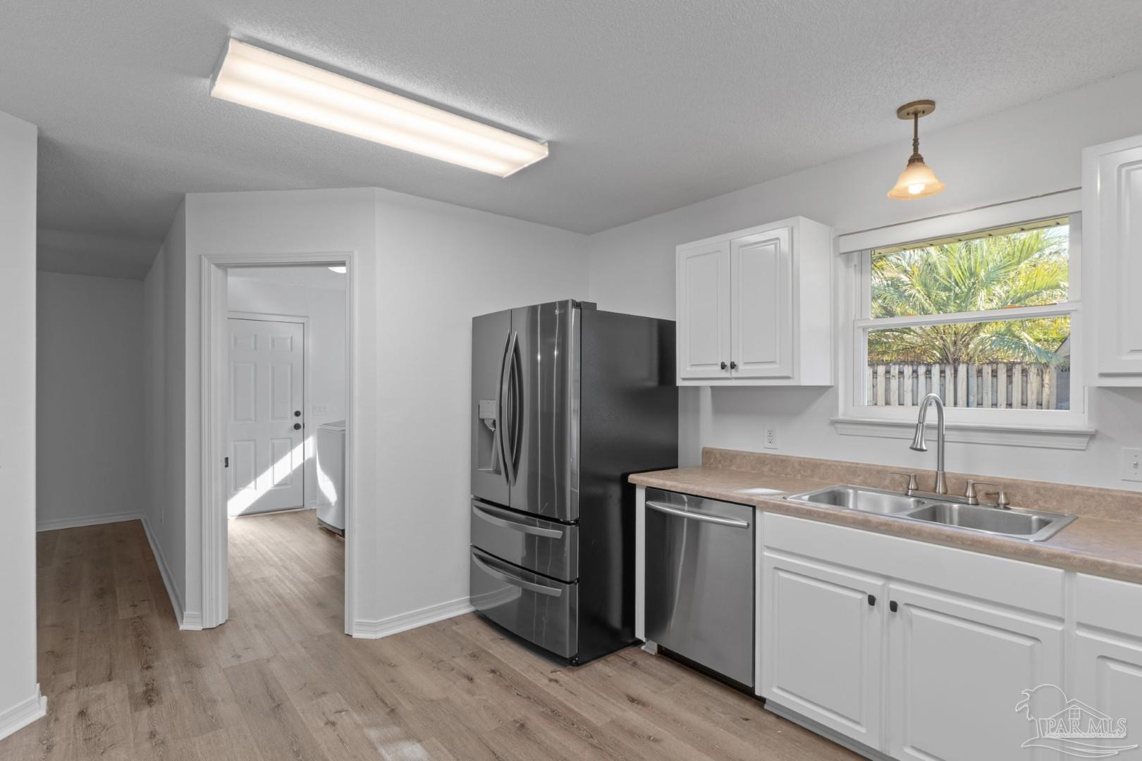 11841 Old Course Road Cantonment, FL 32533 - Photo 20 of 46 a kitchen with a refrigerator sink and cabinets