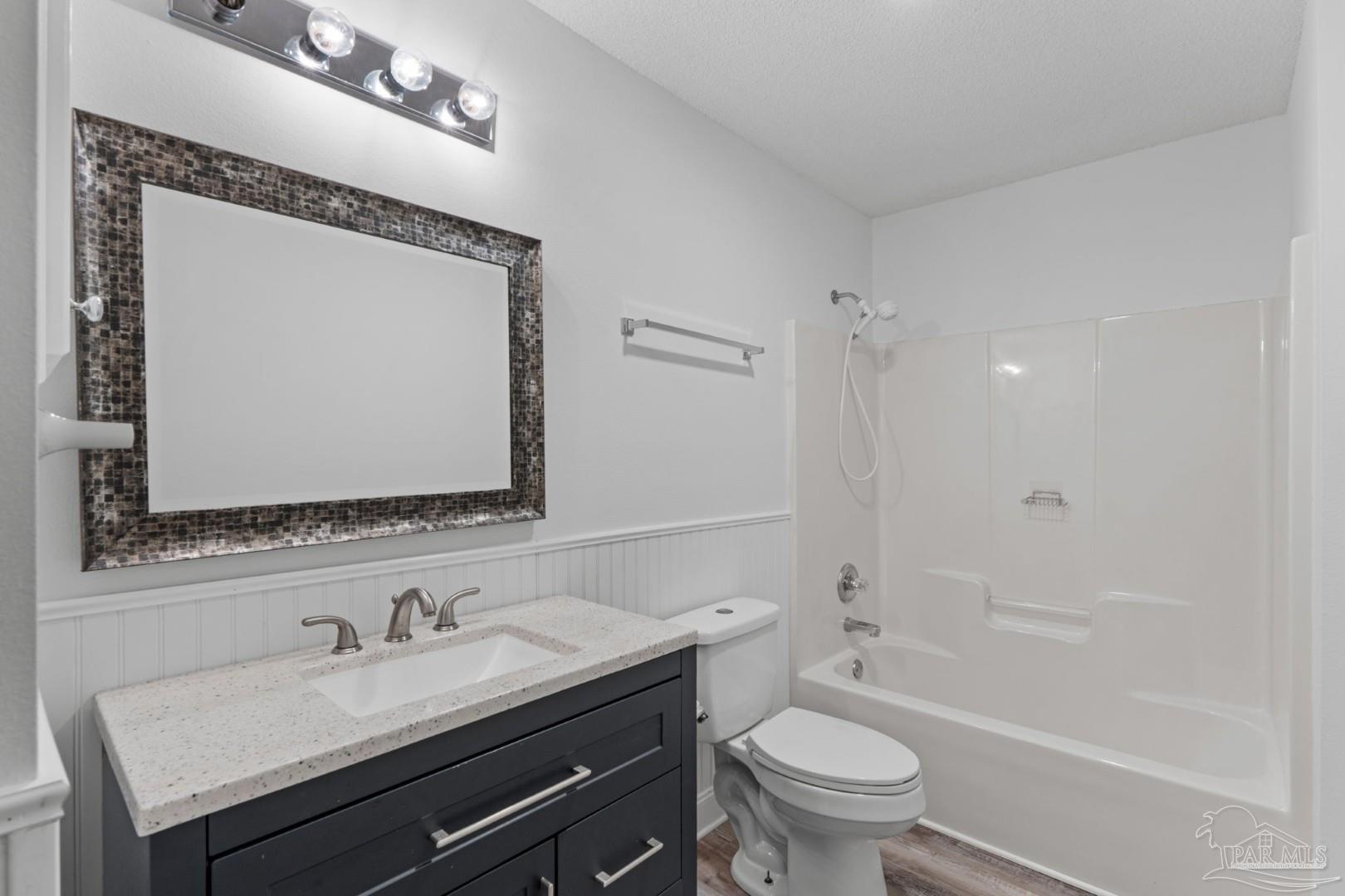 11841 Old Course Road Cantonment, FL 32533 - Photo 28 of 46 a bathroom with a granite countertop sink a toilet and a mirror