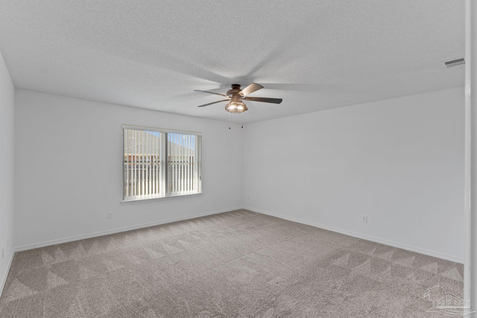 11841 Old Course Road Cantonment, FL 32533 - Photo 29 of 46 an empty room with chandelier fan and windows