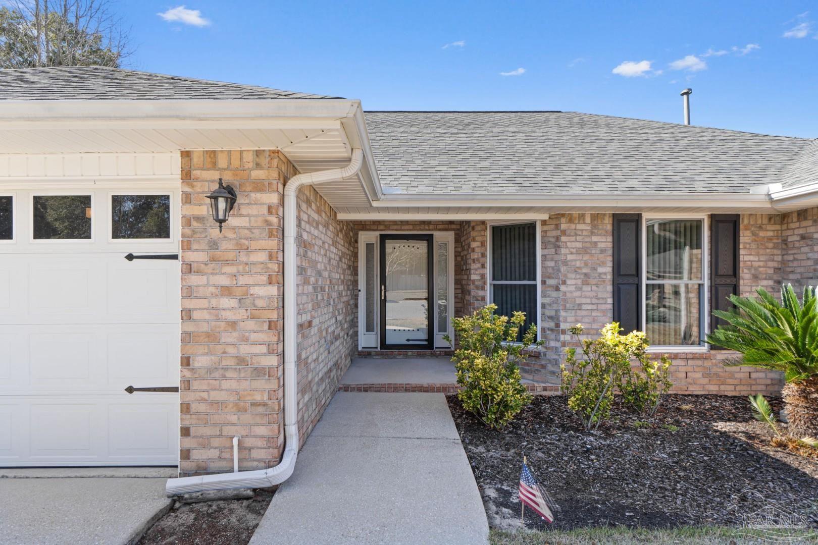 11841 Old Course Road Cantonment, FL 32533 - Photo 4 of 46 a front view of a house with garden