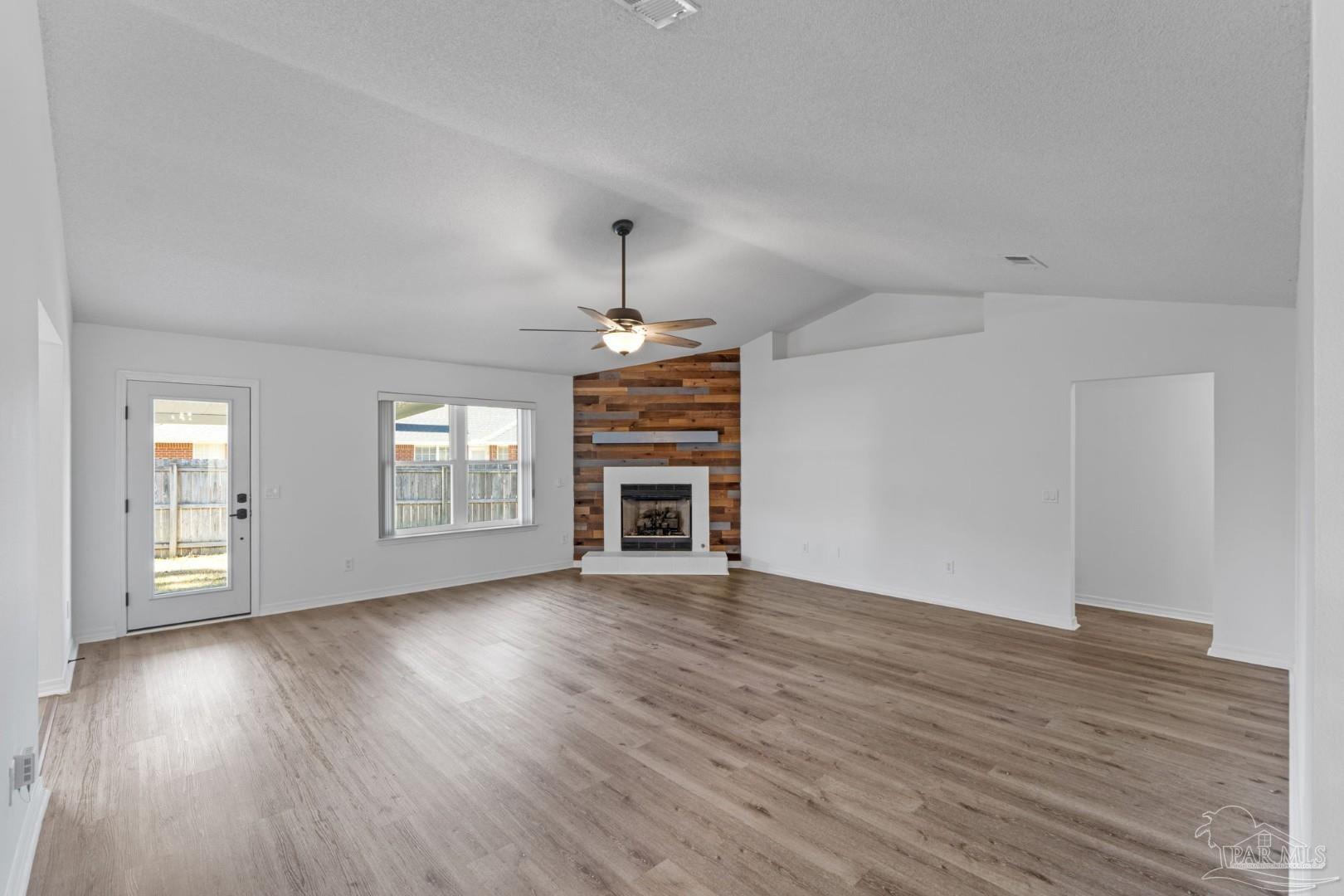 11841 Old Course Road Cantonment, FL 32533 - Photo 10 of 46 an empty room with wooden floor chandelier and windows