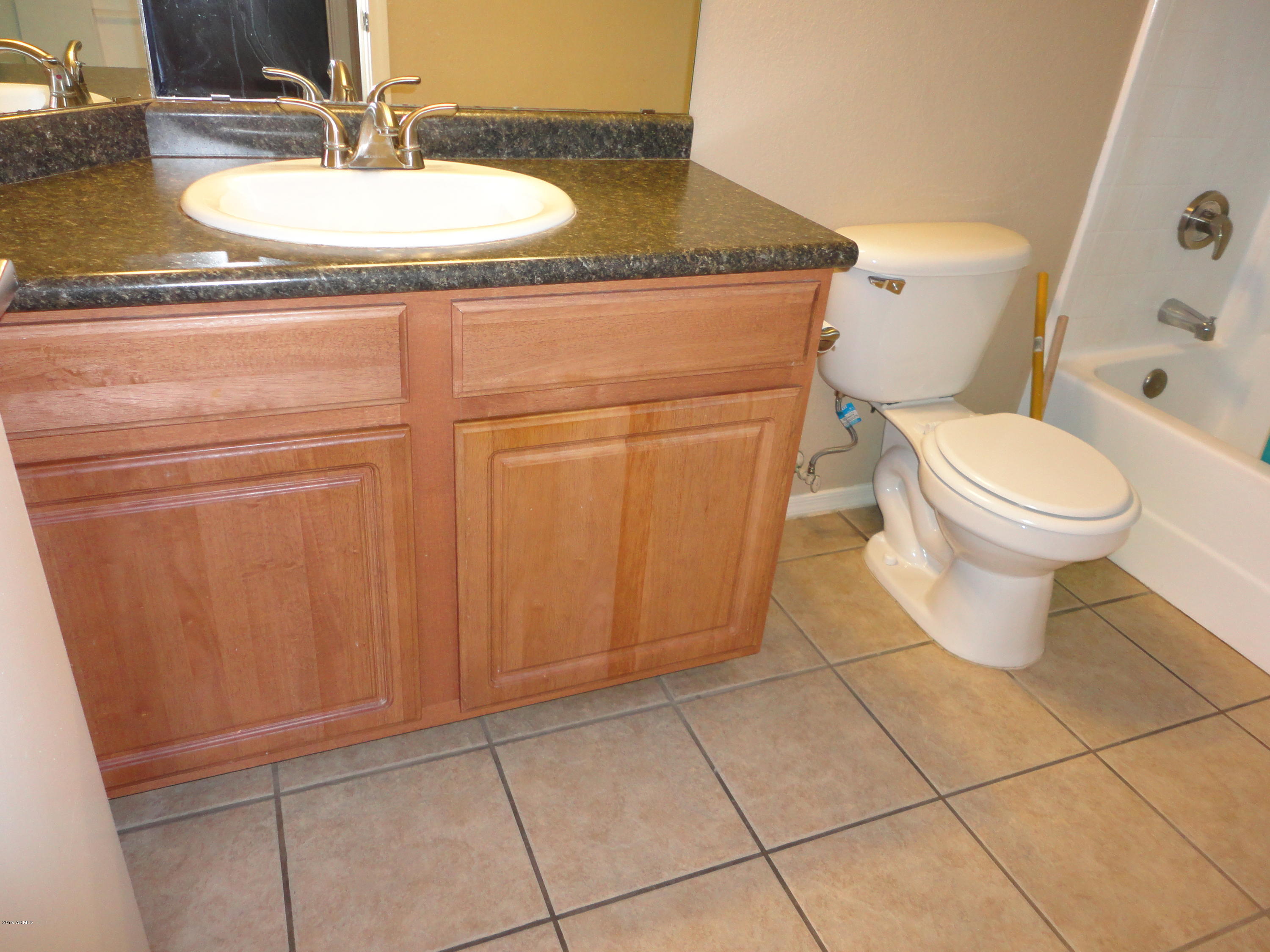 3434 East Baseline Road, Unit 166 Phoenix, AZ 85042 - Photo 12 of 13 a bathroom with a granite countertop sink a toilet and a mirror