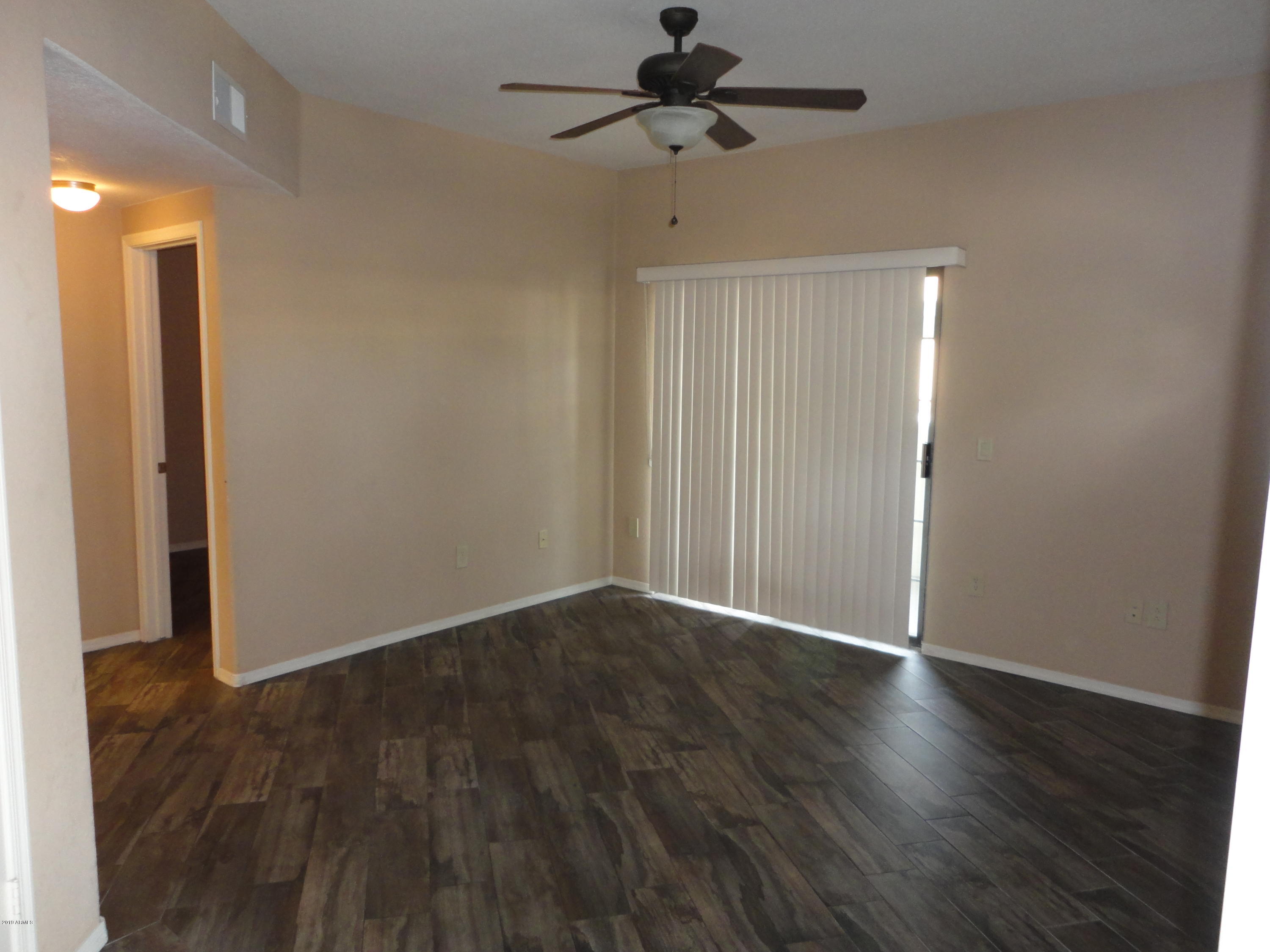 3434 East Baseline Road, Unit 166 Phoenix, AZ 85042 - Photo 3 of 13 a view of an empty room with wooden floor