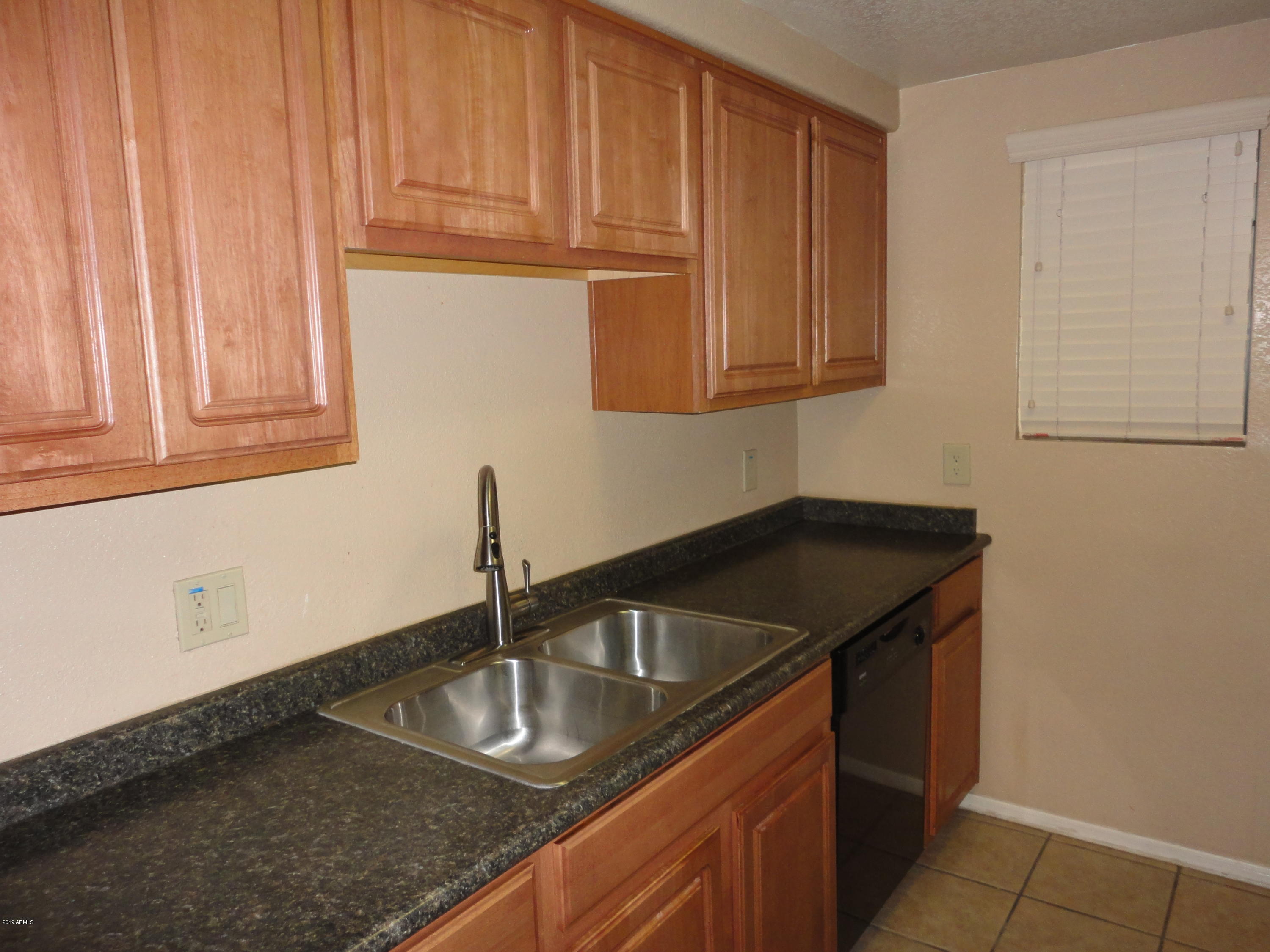 3434 East Baseline Road, Unit 166 Phoenix, AZ 85042 - Photo 8 of 13 a kitchen with granite countertop a sink and a stove