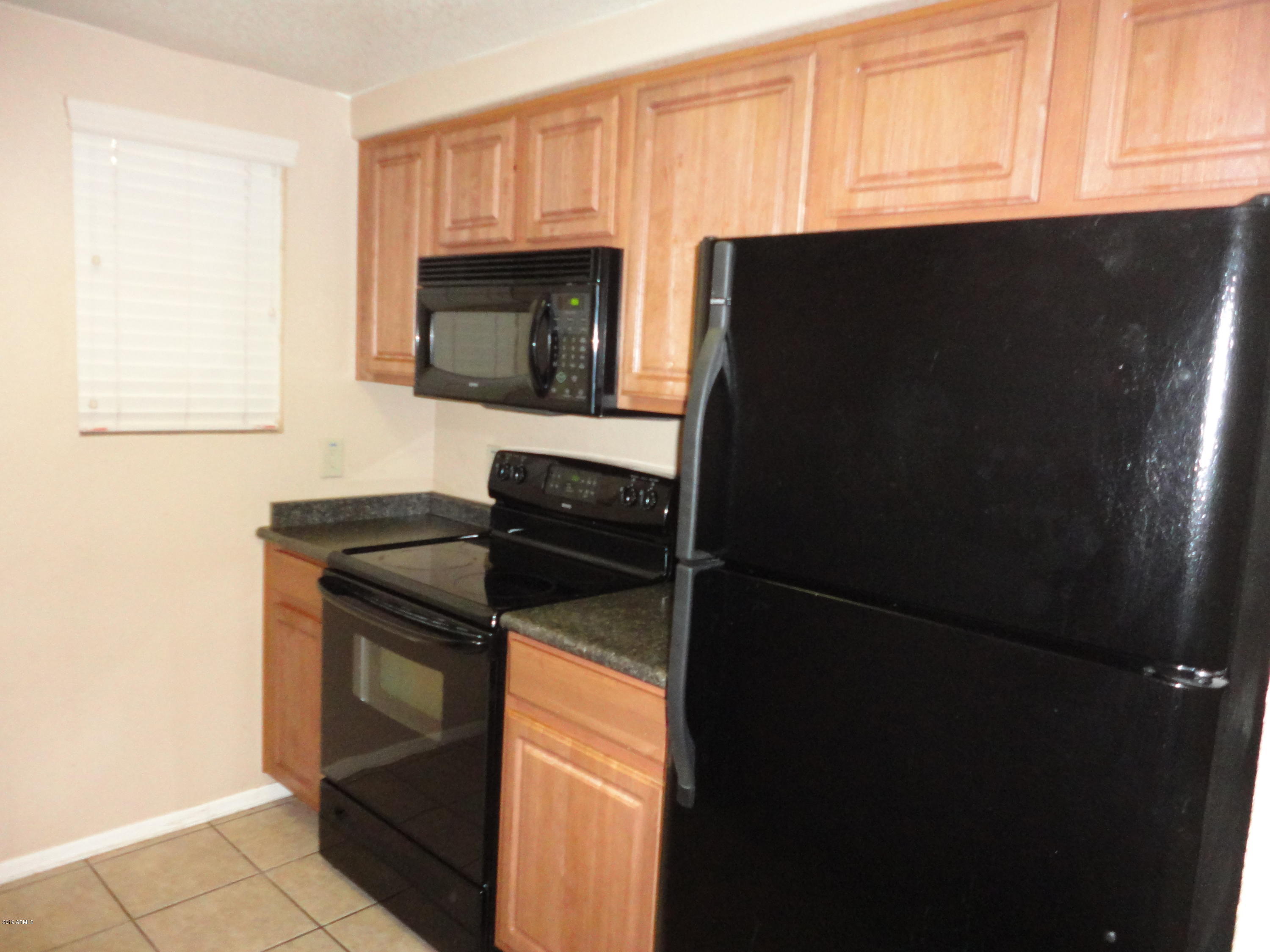 3434 East Baseline Road, Unit 166 Phoenix, AZ 85042 - Photo 9 of 13 a kitchen with a sink and a refrigerator