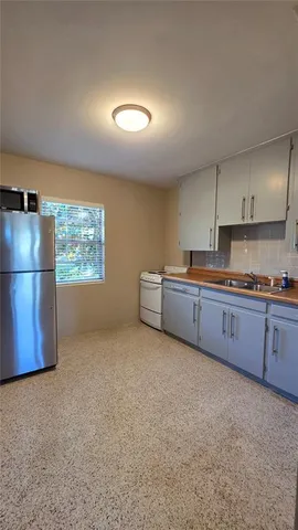 a kitchen with refrigerator and window