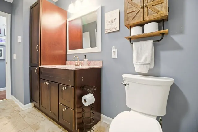 a bathroom with a toilet a sink and mirror