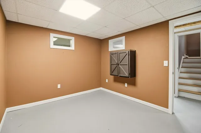 a view of an empty room with window and stairs