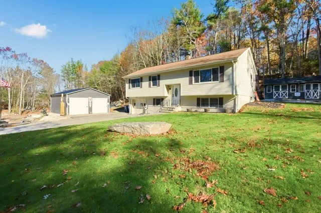 a view of a house with a big yard and large trees