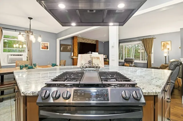 a kitchen with a stove and a granite counter top