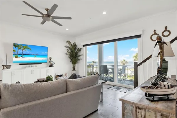 a living room with furniture kitchen view and a potted plant