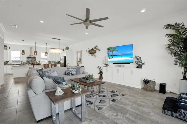 a living room with furniture kitchen view and a chandelier