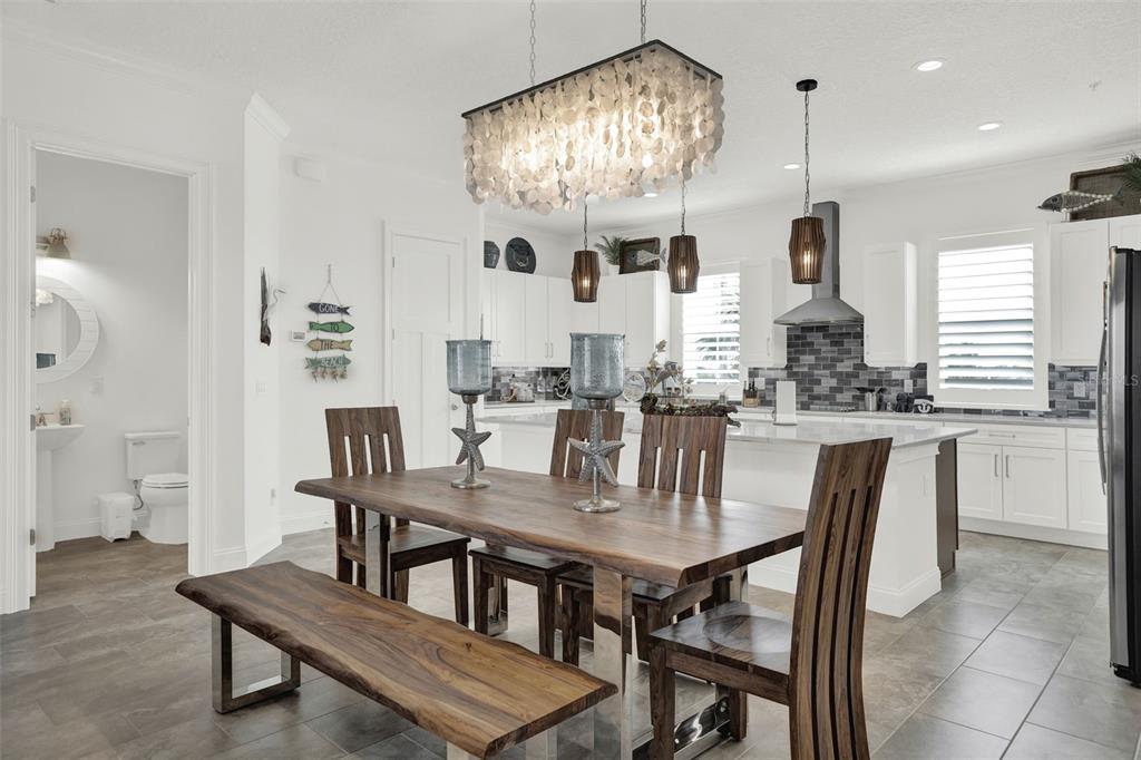 7 Marden Drive Ormond Beach, FL 32176 - Photo 23 of 68 a kitchen with a dining table chairs and chandelier