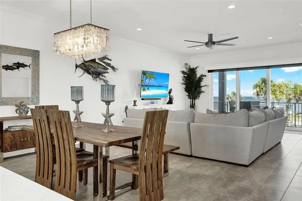 a living room with furniture a chandelier and a dining table