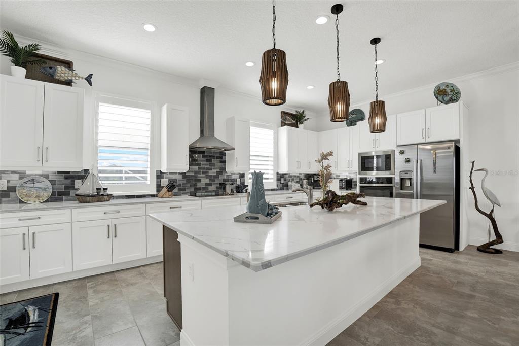 7 Marden Drive Ormond Beach, FL 32176 - Photo 27 of 68 a kitchen with stainless steel appliances kitchen island granite countertop a sink a stove and a wooden floors