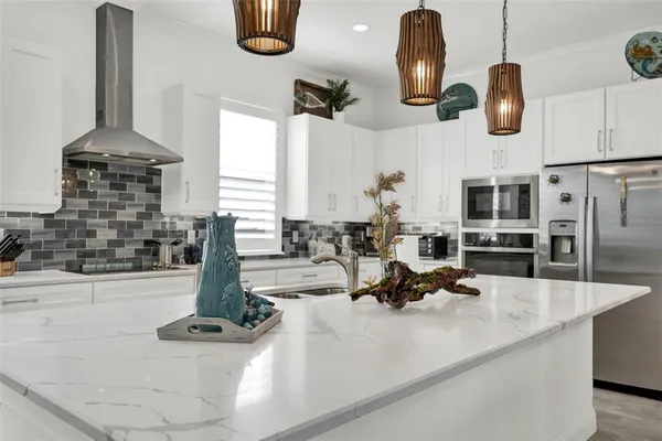 a kitchen with granite countertop white cabinets and white appliances