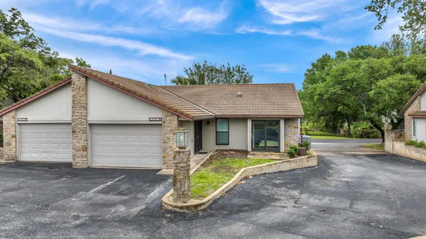 a view of a house with backyard and trees