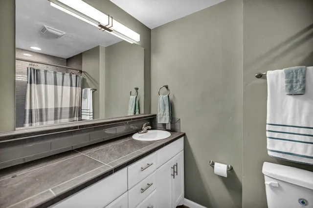 a bathroom with a granite countertop sink and a mirror