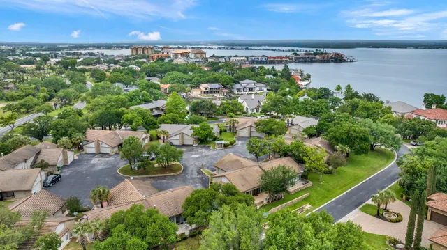 an aerial view of a residential houses with outdoor space and trees