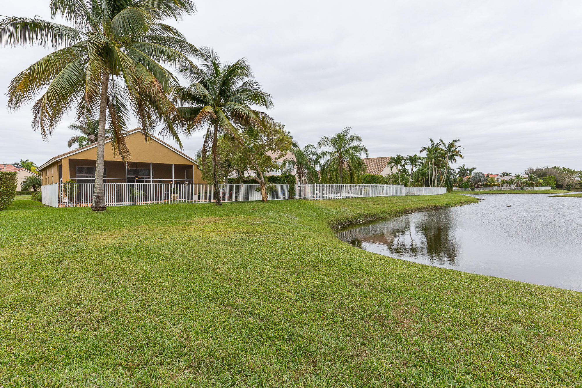 10880 Tea Olive Lane Boca Raton, FL 33498 - Photo 30 of 56 a view of a lake with a big yard and palm trees