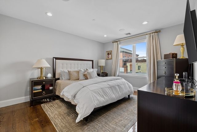 a bedroom with a bed table and flat screen tv