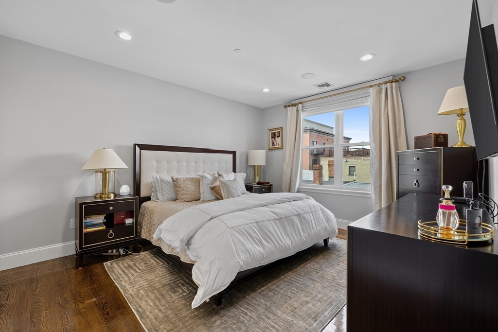 57 L Street, Unit 6 Boston, MA 02127 - Photo 11 of 21 a bedroom with a bed table and flat screen tv