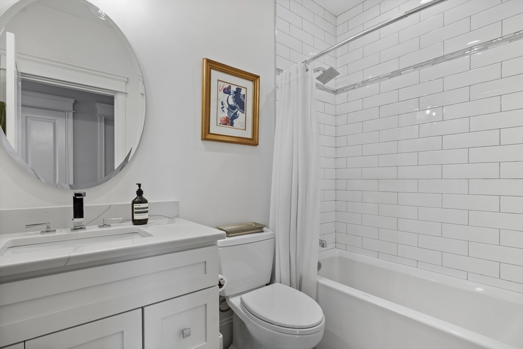 57 L Street, Unit 6 Boston, MA 02127 - Photo 18 of 21 a bathroom with a toilet a sink a mirror and shower