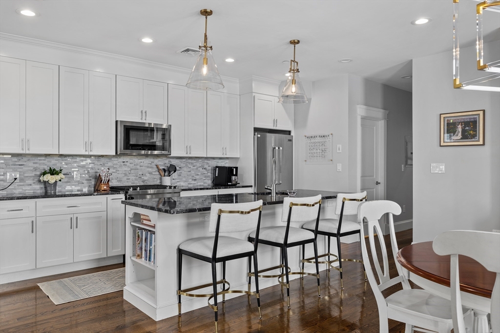57 L Street, Unit 6 Boston, MA 02127 - Photo 2 of 21 a kitchen with a dining table chairs cabinets and stainless steel appliances