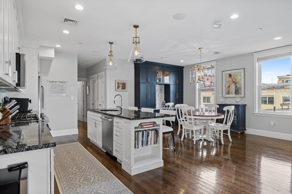 57 L Street, Unit 6 Boston, MA 02127 - Photo 4 of 21 a kitchen with stainless steel appliances granite countertop a stove top oven a sink a dining table and chairs