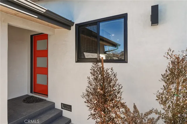 a view of a dining room and livingroom with furniture wooden floor a rug a painting and a chandelier