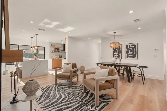 a dining room with furniture a chandelier and wooden floor