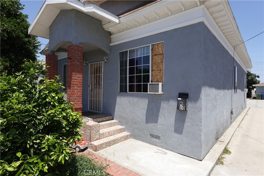 a view of a brick house with potted plants