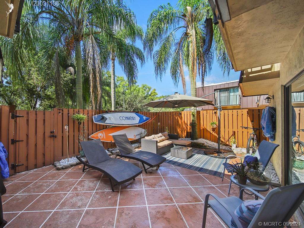 5804 Southeast Windsong Lane Stuart, FL 34997 - Photo 14 of 20 a backyard of a house with barbeque oven table and chairs