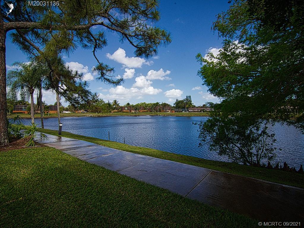 5804 Southeast Windsong Lane Stuart, FL 34997 - Photo 17 of 20 a view of a yard with swimming pool and lake view in back